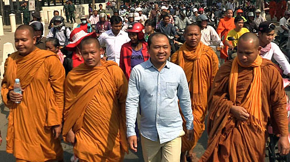 Cambodian political analyst Kim Sok (C) walks with his supporters as he heads to the municipal courthouse in Phnom Penh, Feb. 17, 2017.