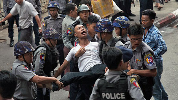 Myanmar police detain a demonstrator during an antiwar protest in Yangon, May 12, 2018.