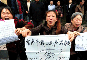 Chinese women petitioners kneeling as they cry outside a court in southwest China's Chongqing municipality, May 13, 2010.