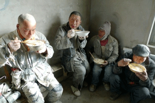 Workers eat noodles at the Jiaersi Green Construction factory in northwest China's Xinjiang region, Dec. 11, 2010.