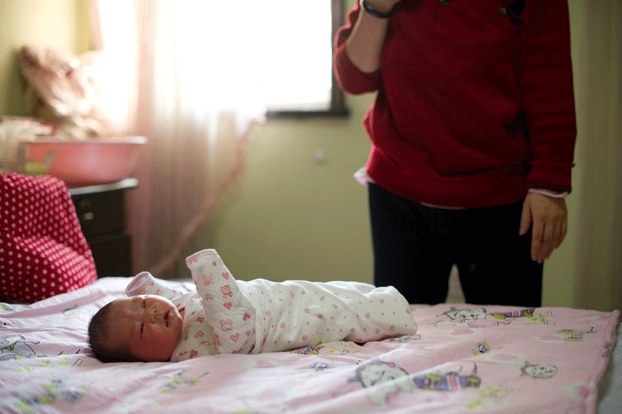 A Chinese mother stands by her newborn baby girl at a maternity hospital in Beijing, Jan. 26, 2012.