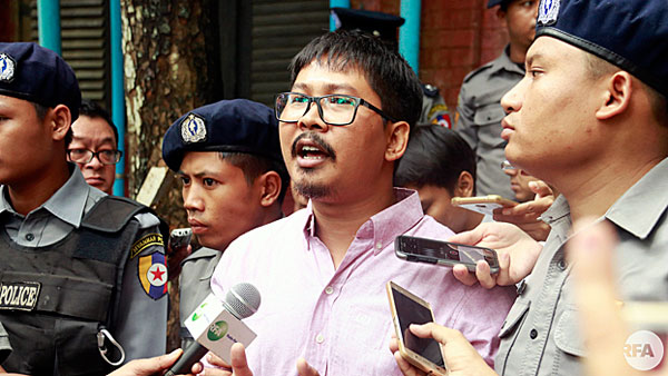 Detained Myanmar journalist Wa Lone (C) speaks to reporters during a break in his ongoing pretrial hearing at a court in Yangon, July 2, 2018.