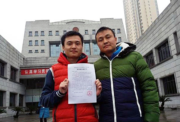 Sun Wenlin (L) and his partner Hu Mingliang file a lawsuit against the Furong district civil affairs bureau for refusing their application to marry in Changsha, provincial capital of southern China's Hunan province, Dec. 16, 2015.