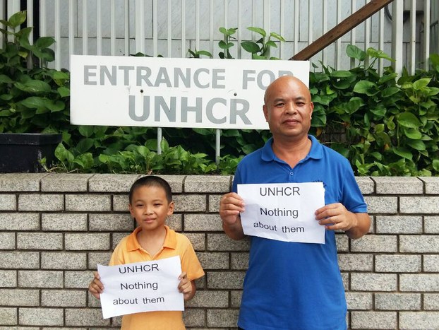 Asylum-seeker Li Xiaolong (R), whose wife Gu Qiao is currently facing deportation from Thailand, protesting with his son at the UNHCR office in Bangkok, July 29, 2016.