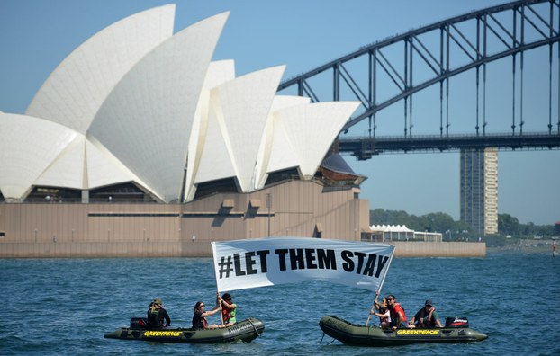 Members of the environmental group Greenpeace hold up a sign that reads '#LET THEM STAY' in a protest over Australia's refugee policies, Feb. 14, 2016.
