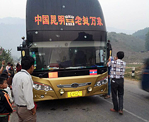 Locals examine the front of a Chinese passenger bus that was shot by unidentified gunmen in northern Laos, March 23, 2016.