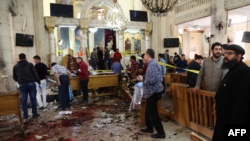 (WARNING: Graphic) People look at the aftermath following a bomb blast that struck worshipers gathering to celebrate Palm Sunday at the Mar Girgis Coptic Church in the Nile Delta city of Tanta, 120 kilometers north of Cairo, on April 9.