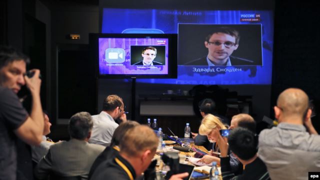 Journalists in Moscow listen to a speech and a question posed by former NSA contractor Edward Snowden at a media center during Russian President Vladimir Putin's nationwide phone-in program in April 2014.