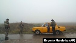 Ukrainian police officers stop a car to check documents at a checkpoint in Berdyansk in eastern Ukraine on November 28.