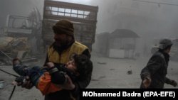 An injured boy is carried to an ambulance after an air attack in the rebel-held city of Duma, in eastern Ghouta.
