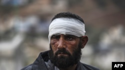 An injured Syrian man who arrived on the Syrian side of the Bab al-Hawa border crossing between Syria and Turkey waits outside a hospital on December 16.