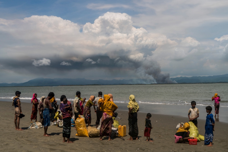 أسرٌ من الروهينغا تتجمع على الشاطئ في داخينبارا، بنغلاديش، بعد عبور البحر على متن قوارب صيد من ميانمار.