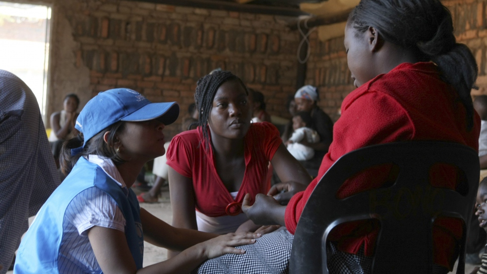 UNHCR Protection Officer Kamini Karlekar and Julieth Gudo (shelter staff) speak to women and children at the United Reformed Church's shelter for Gender Based Violence in Nancefield Musina.