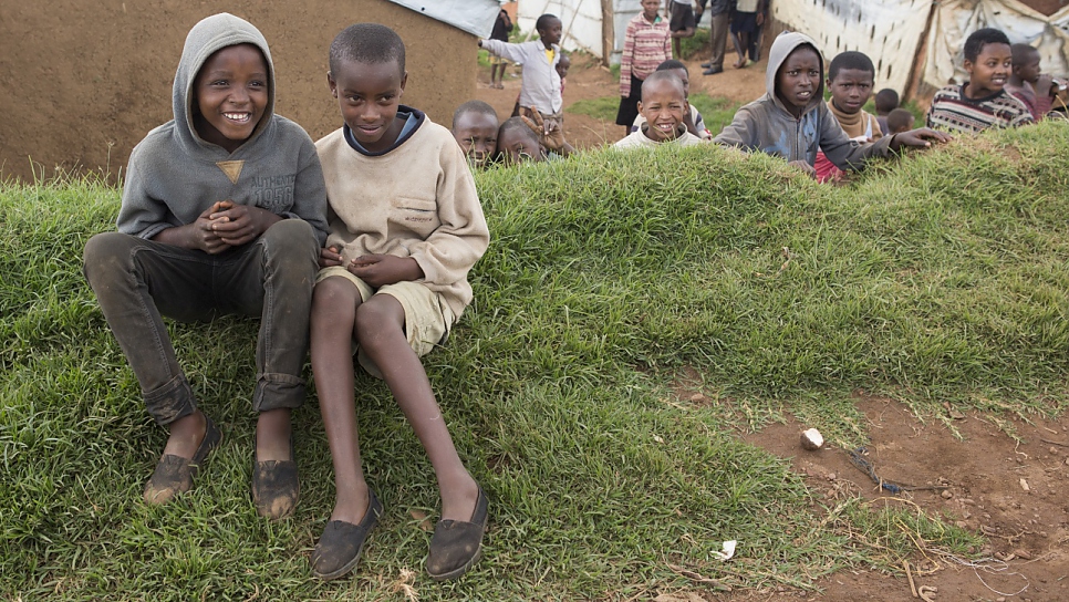 2 Congolese refugee boys wear Tom Shoes in Gihembe refugee camp. There are over 12,995 refugees in Gihembe camp of whom 97% are Congolese. Most of the people here have been refugees for 20 years and are survivors of the Mudende camp massacre.