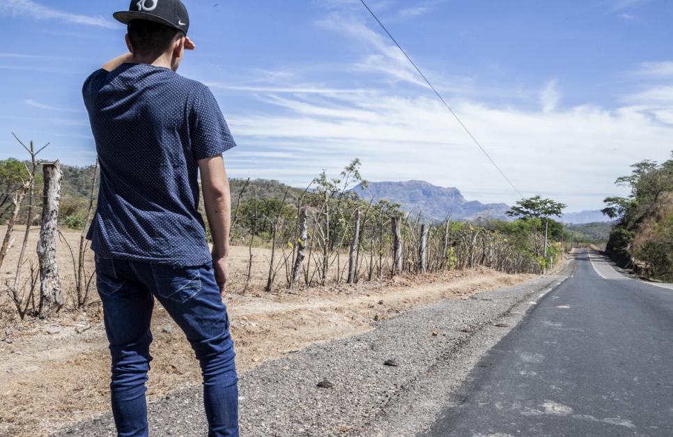 Un déplacé interne se tient près d'une route de campagne au Salvador. Il a été victime du harcèlement d'un gang de rue, ce qui l'a poussé à fuir son domicile au Salvador. Photo d'archives, janvier 2019. 