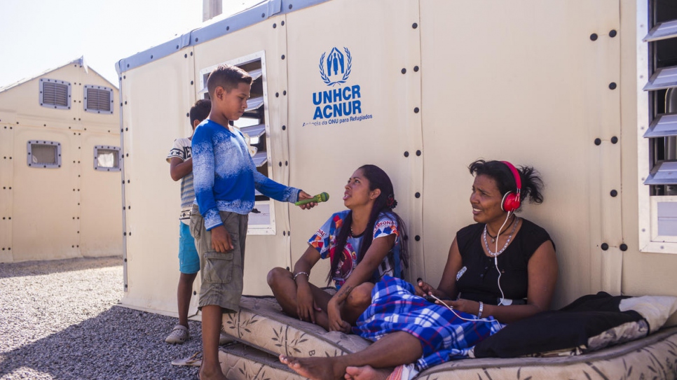 Moisés plays journalist, interviewing refugees in front of their shelter in Rondon 3 refugee camp in Boa Vista, Brazil.