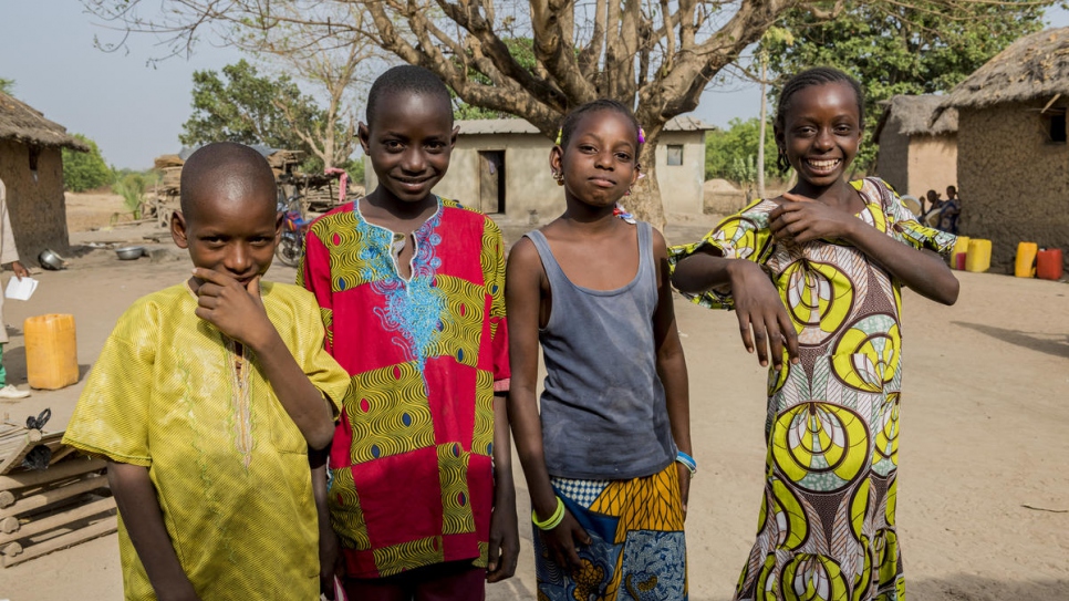 Abdul, Boukary Aisha, and Adiba (left to right) pose for a picture in Kong, Côte d'Ivoire. They are the first generation of the extended Tall family to go to school.
