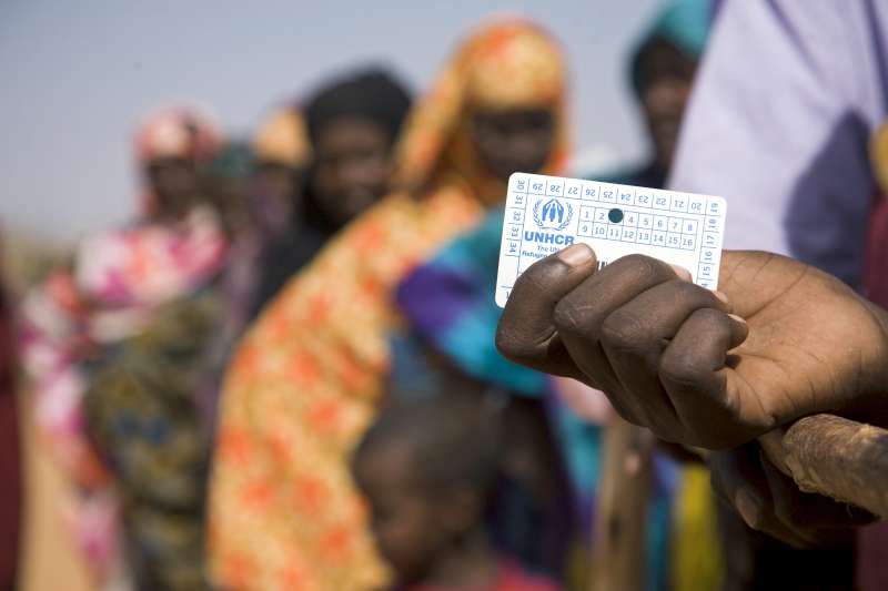 Ethiopia / Ogaden, Somali Region, Dollo Ado, South East Ethiopia / Refugees are waiting for NFI's like plastic sheets and jerry cans. On the photograph, a woman is holding her registration card. Hundreds of Somali people, mainly women and children have fled their home country to seek shelter in Ethiopia. UNHCR has constructed a transit center and is constructing a new refugee camp. 