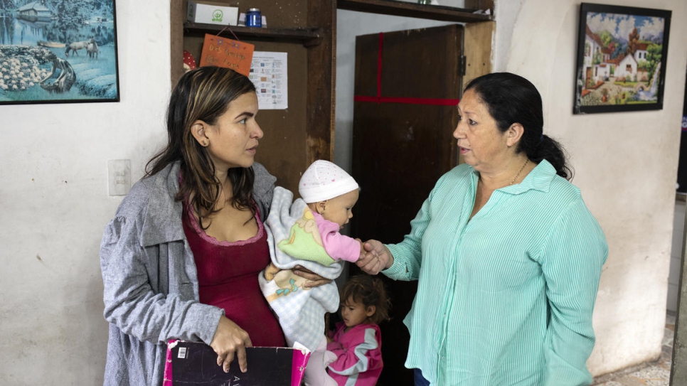 Marta Duque advises a Venezuelan woman with her children on the difficulties they may encounter on their journey through the mountains.