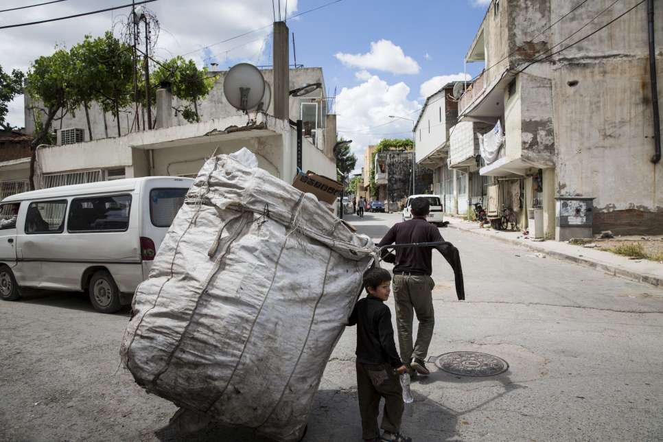 The collection point provides a trolley, which Firas manages to pull despite missing his lower left arm and  having an injured right hand.