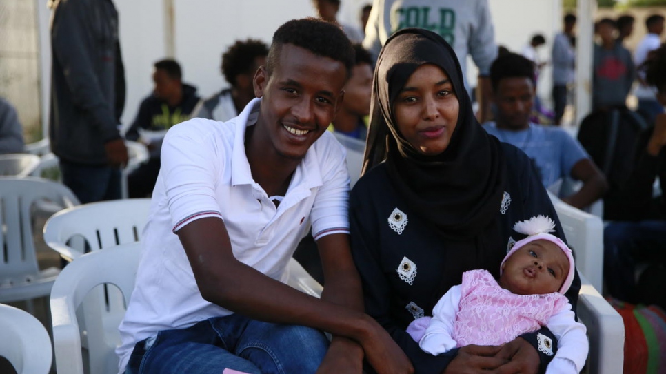 Somali parents Abdulbasit and Zainab sit with their two-month-old daughter at the Gathering and Departure Facility in Tripoli ahead of the evacuation flight to Rwanda.