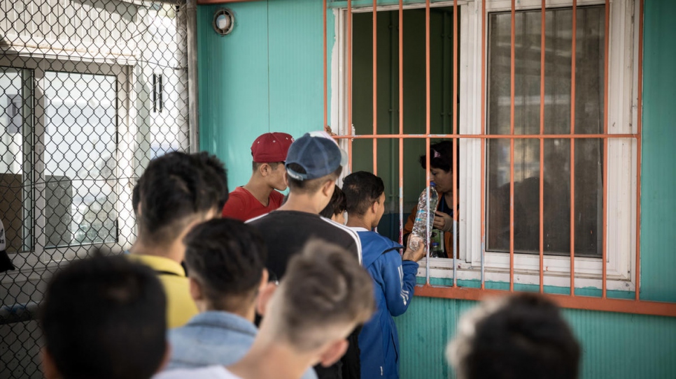 Des jeunes non accompagnés originaires d'Afghanistan et de Syrie font la queue pour recevoir un repas à la Section A du centre de réception de Moria. 