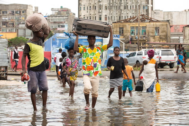 Des habitants portent des effets personnels dans une section inondée de la ville de Praia Nova, Beira, Mozambique, après le passage du cyclone Idai. 