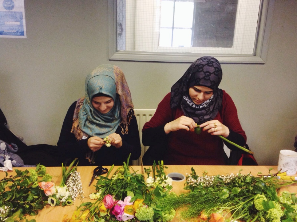 Women create flower arrangements together at a Bread and Roses workshop