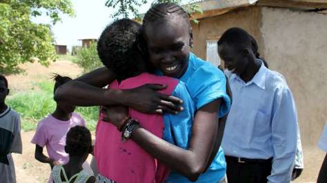 Supermodel, former refugee and UNHCR Refugee Advocate, Alek Wek greets a woman in a returnee community in Juba, South Sudan. UNHCR/B.Sokol/July 9, 2012