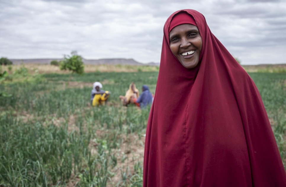 المزارعة اللاجئة كاها عبد الله تقف إلى جانب محاصيل مروية في ملكاديدا، إثيوبيا.