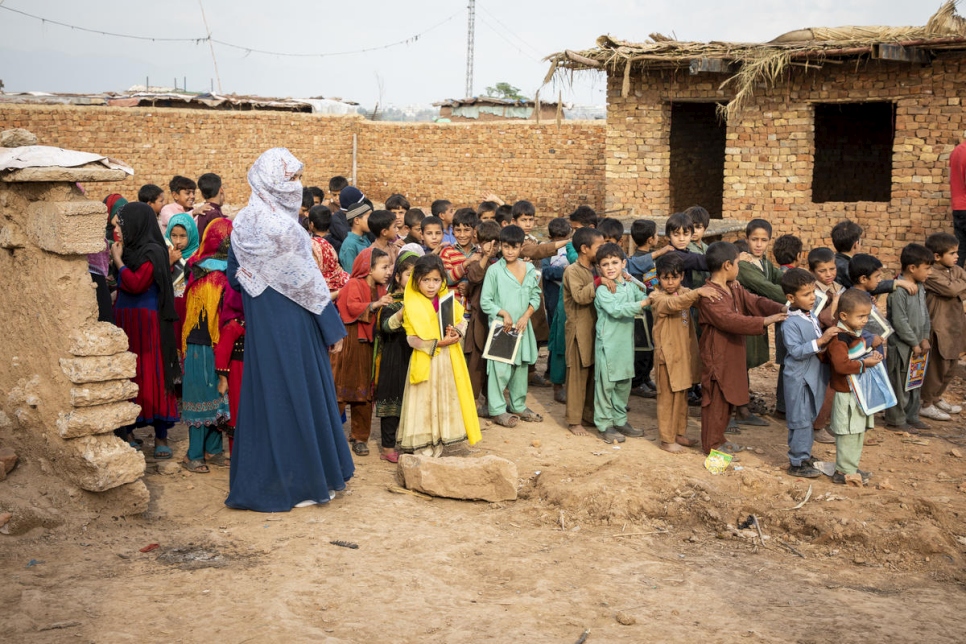 Des enfants réfugiés afghans dans la cour d'une école de fortune de l'installation 12-Secteur I à Islamabad au Pakistan. 