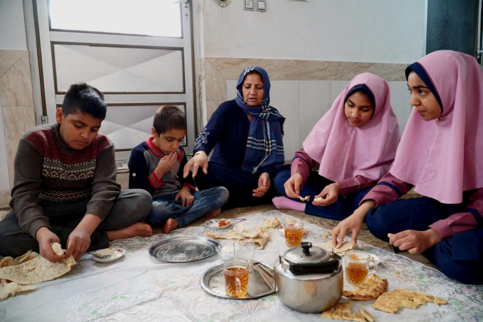 اللاجئة الأفغانية حليمة (وسط) تناول الإفطار مع أطفالها في منزل العائلة في أصفهان، وسط إيران.