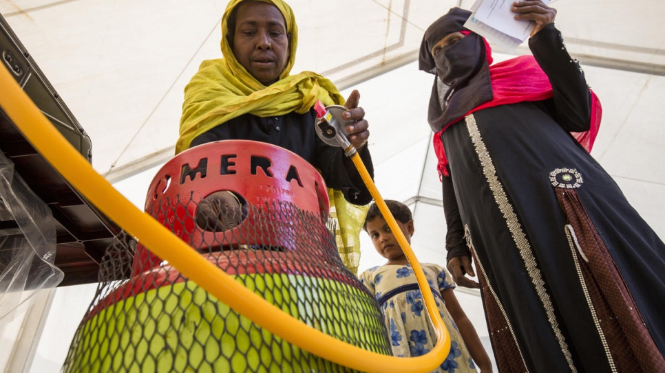 Rohingya refugees receive training on how to operate new gas stoves at a distribution centre in Kutupalong Refugee Camp.