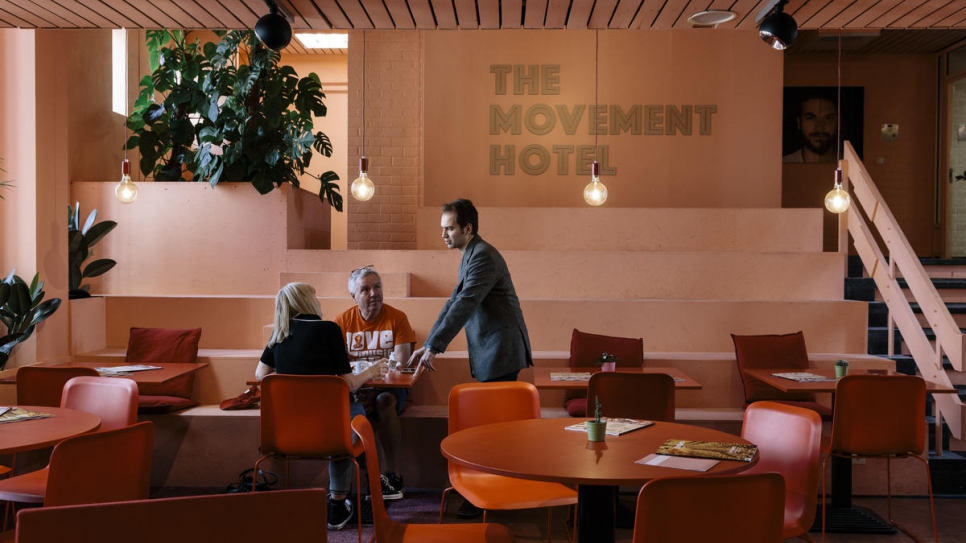 Receptionist Wassim Al Wattar, a refugee from Syria, chats to guests at the Movement Hotel in Amsterdam.