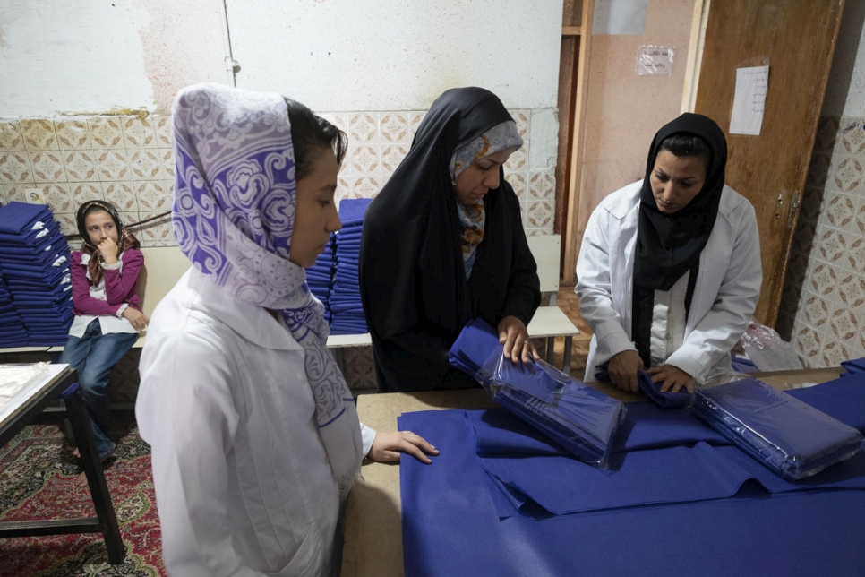 زينب (وسط) تشرف على زميلاتها من اللاجئات الأفغانيات في ورشة الخياطة الخاصة بها في شيراز. 
