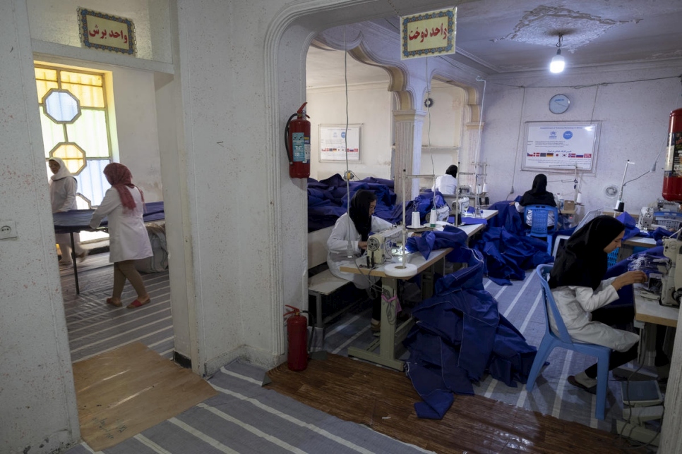 عاملات إيرانيات وأفغانيات يعملن في ورشة الخياطة. 