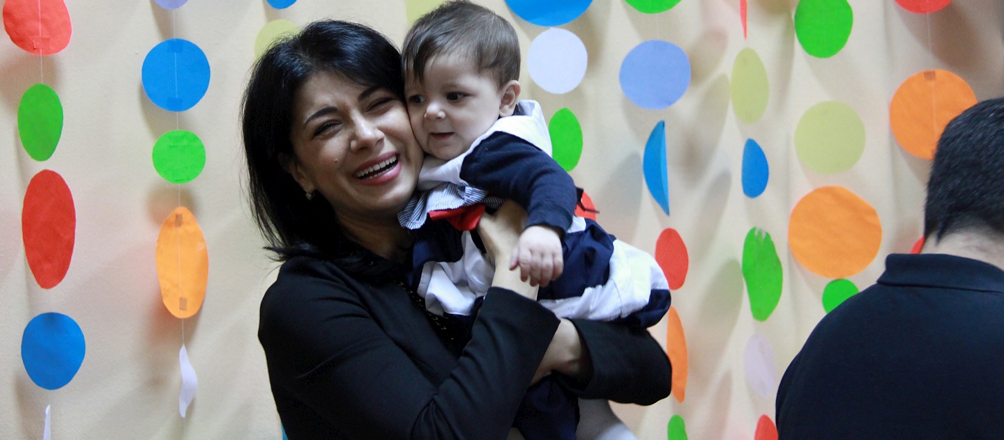 UNHCR Goodwill Ambassador Iskui Abalyan mets a family of resettled refugees in Gomel, Belarus in April 2016. During the mission, she visited the Temporary Accommodation Centre (TAC) to meet refugees from different countries (Ukraine, Syria, Georgia). This photo was taken with a Syrian family at the TAC. They were resettled under the first and the only joint resettlement project of UNHCR and the Ministry of Internal Affairs of Belarus. The family was resettled from Syria to Gomel in February 2015. 