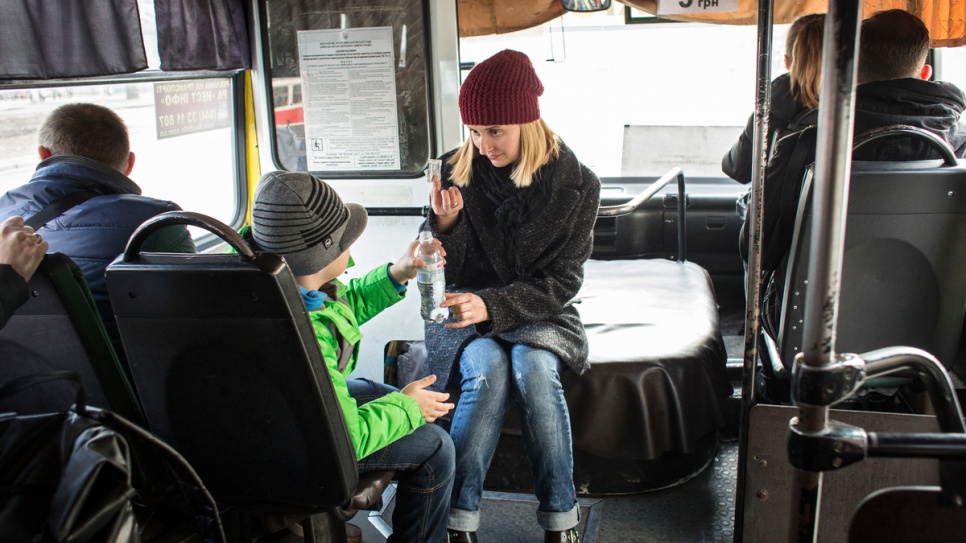 Anna and her son Igor take the bus home to their rented apartment.