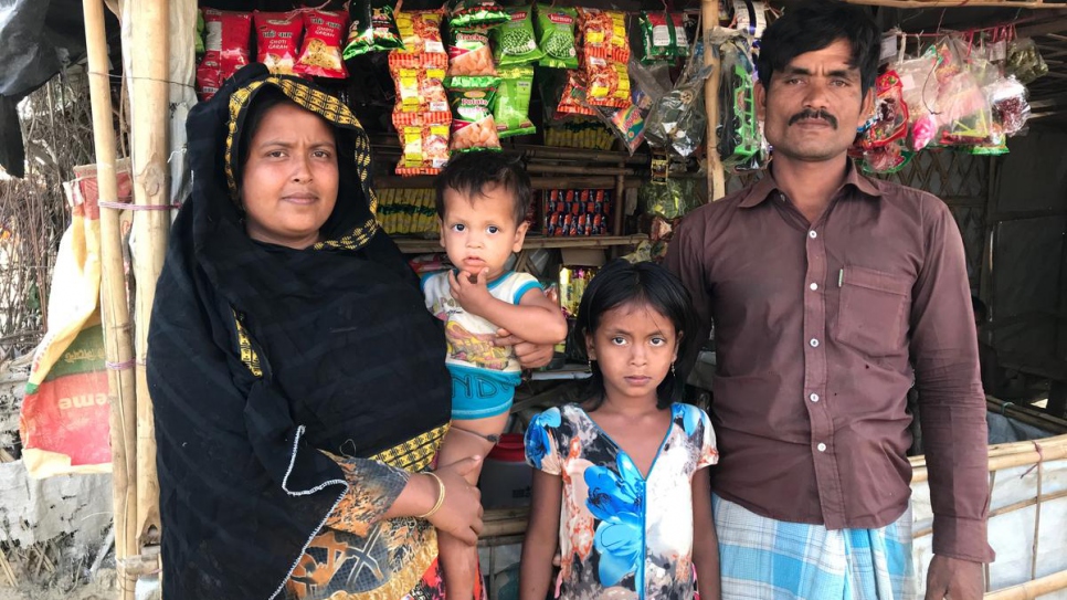 Rohingya parents Lalu Begum and Nurul Salam stand in front of their tea shop in Kutupalong refugee settlement, Bangladesh, with two of their children.