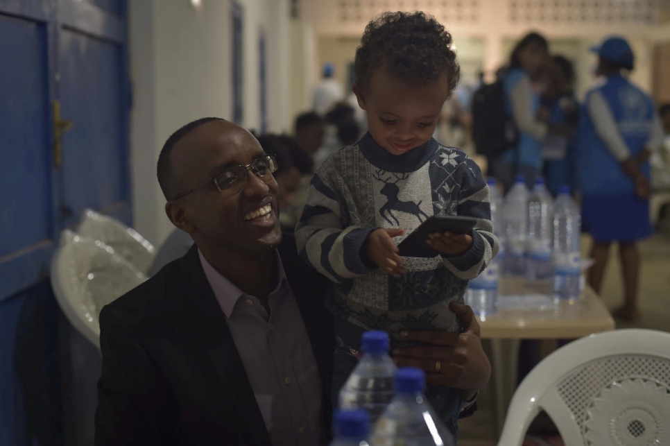 رئيس بلدية المنطقة، ريتشارد موتابازي، مع أحد الأطفال في مركز العبور الطارئ في غاشورة، رواندا. 