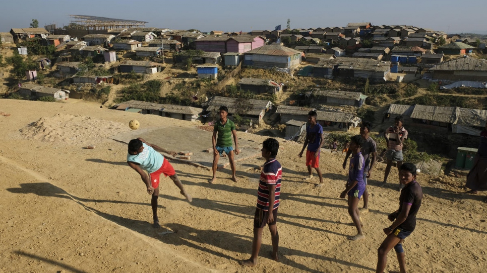 Rohingya youth play a game of football in a clearing at Chakmarkul refugee camp in Cox's Bazar, Bangladesh.