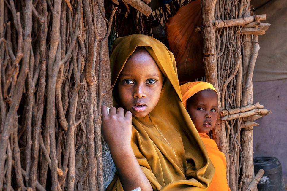 Five-year-old Somali refugee Filsan looks out from her home in Dadaab, Kenya, with her three-year-old sister Sundus. The siblings were born in Ifo refugee camp and the elder has ambitions she is already trying to fulfil through school.