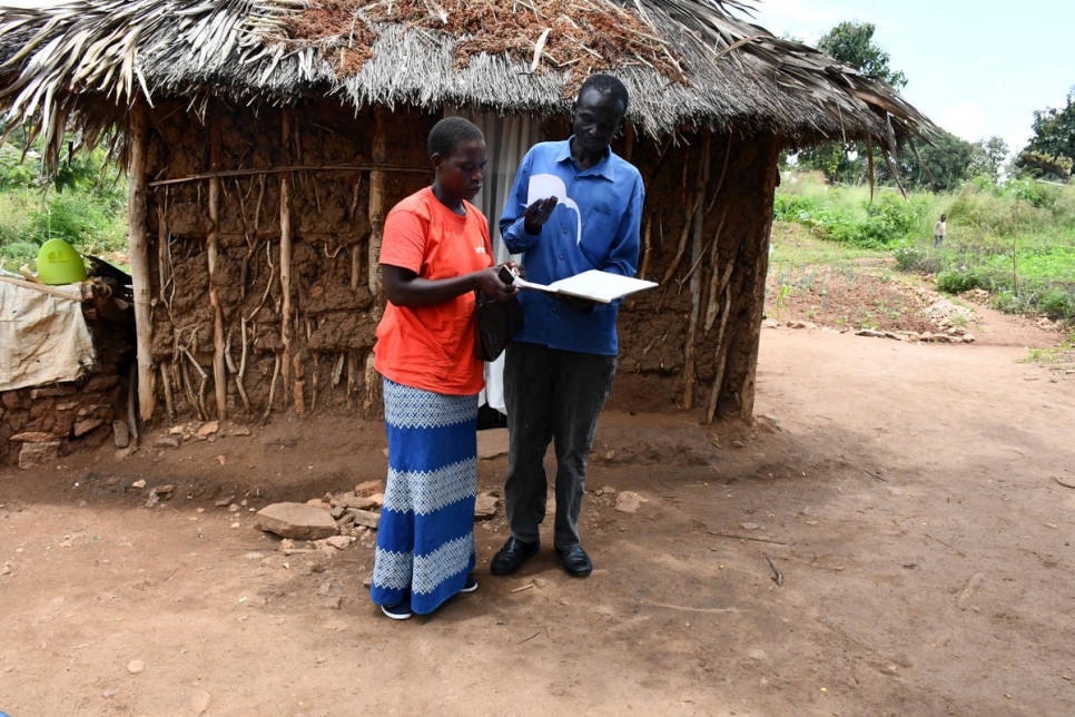 South Sudanese refugees Inga Viola (left) and Rufas Taban check paperwork from their support and savings cooperative at Imvepi refugee settlement in Uganda.