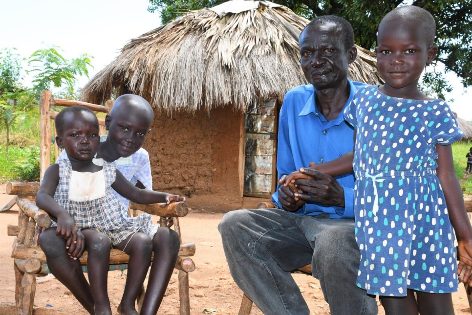 Rufas Taban sits with his three children (from left) Maria, Joseph and Blessing outside his shelter in Imvepi settlement, Uganda.
