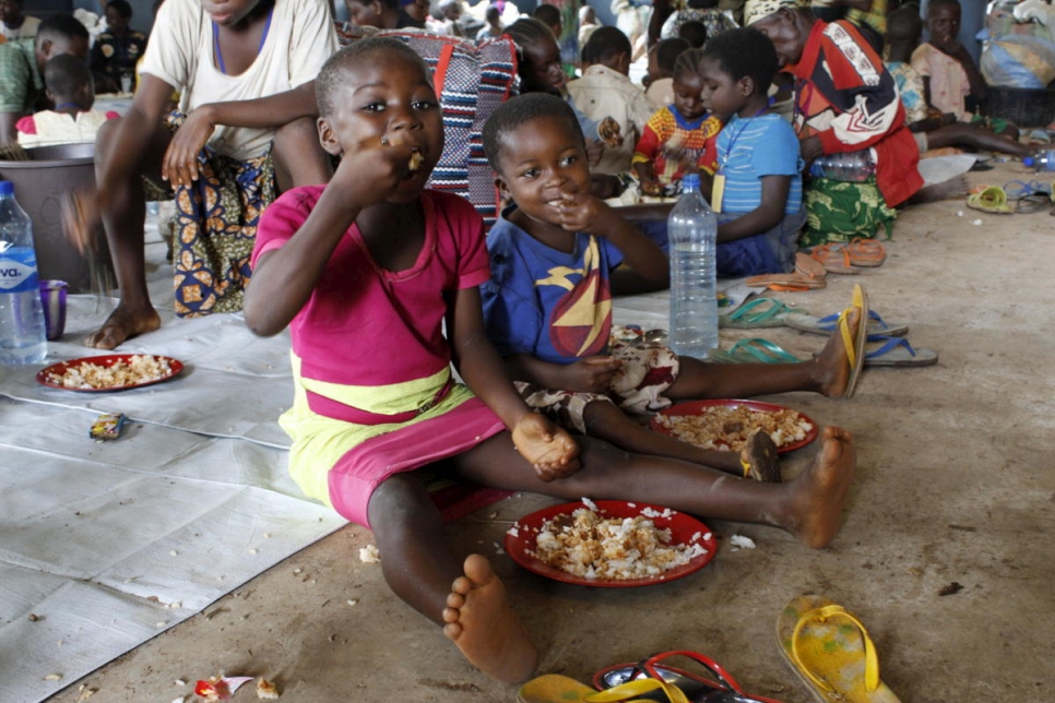 Des enfants réfugiés camerounais prennent leur premier repas après leur arrivée dans l'installation d'Adagom au Nigéria. 