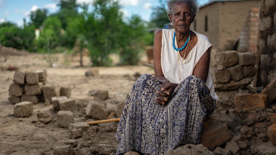 Rwandan refugee Magdalena Niragire sits by the rubble of her home partly demolished by torrential rains that pounded Tongogara refugee camp, Zimbabwe.