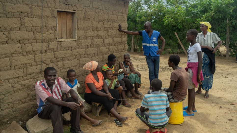 A UNHCR worker talks with the family of Magdalena Niragire at Tongogara refugee camp, Zimbabwe.