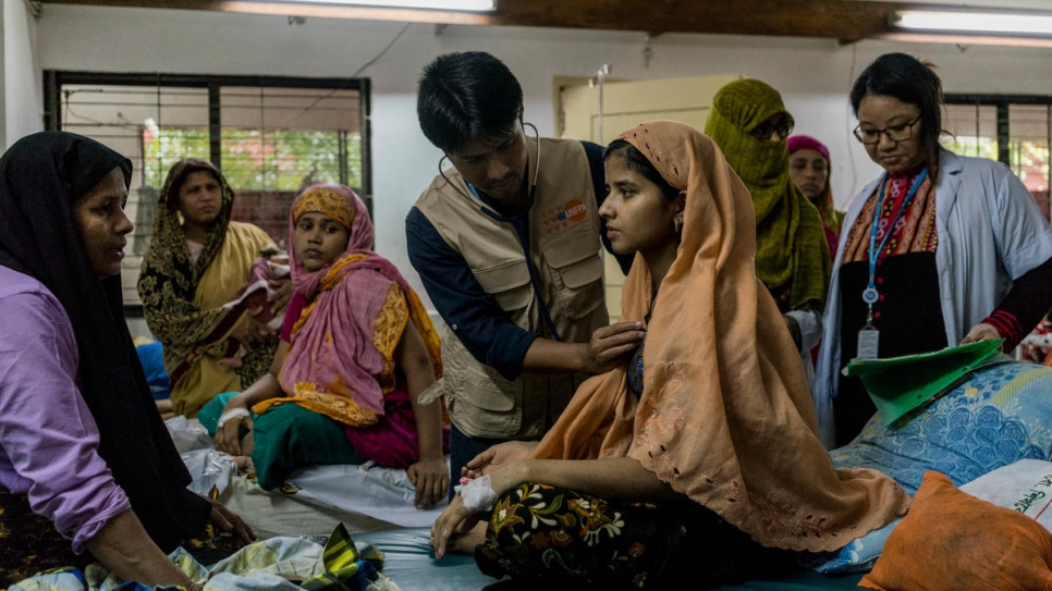 Sailesh Rajbanshi, gynécologue-obstétricien travaillant pour le Fonds des Nations Unies pour la population, en train d'examiner Milishi, 18 ans, une réfugié rohingya dans une unité mixte accueillant des patients réfugiés et bangladais à l'Hôpital de Sadar à Cox's Bazar, au Bangladesh. 