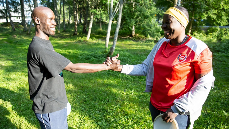 Nakout shakes hands with her friend Henry at the end of a game of frisbee golf, a popular local game she has taken up to keep fit and make friends in her new hometown of Vaasa in Finland.
