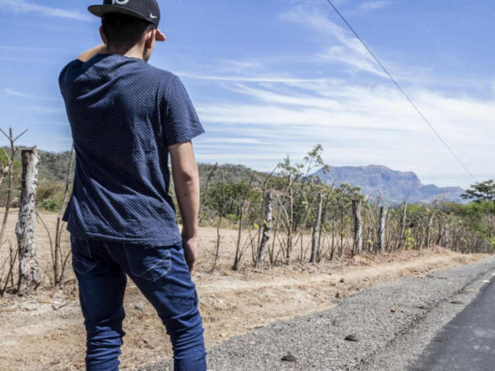 Internally displaced man looks down on rural road